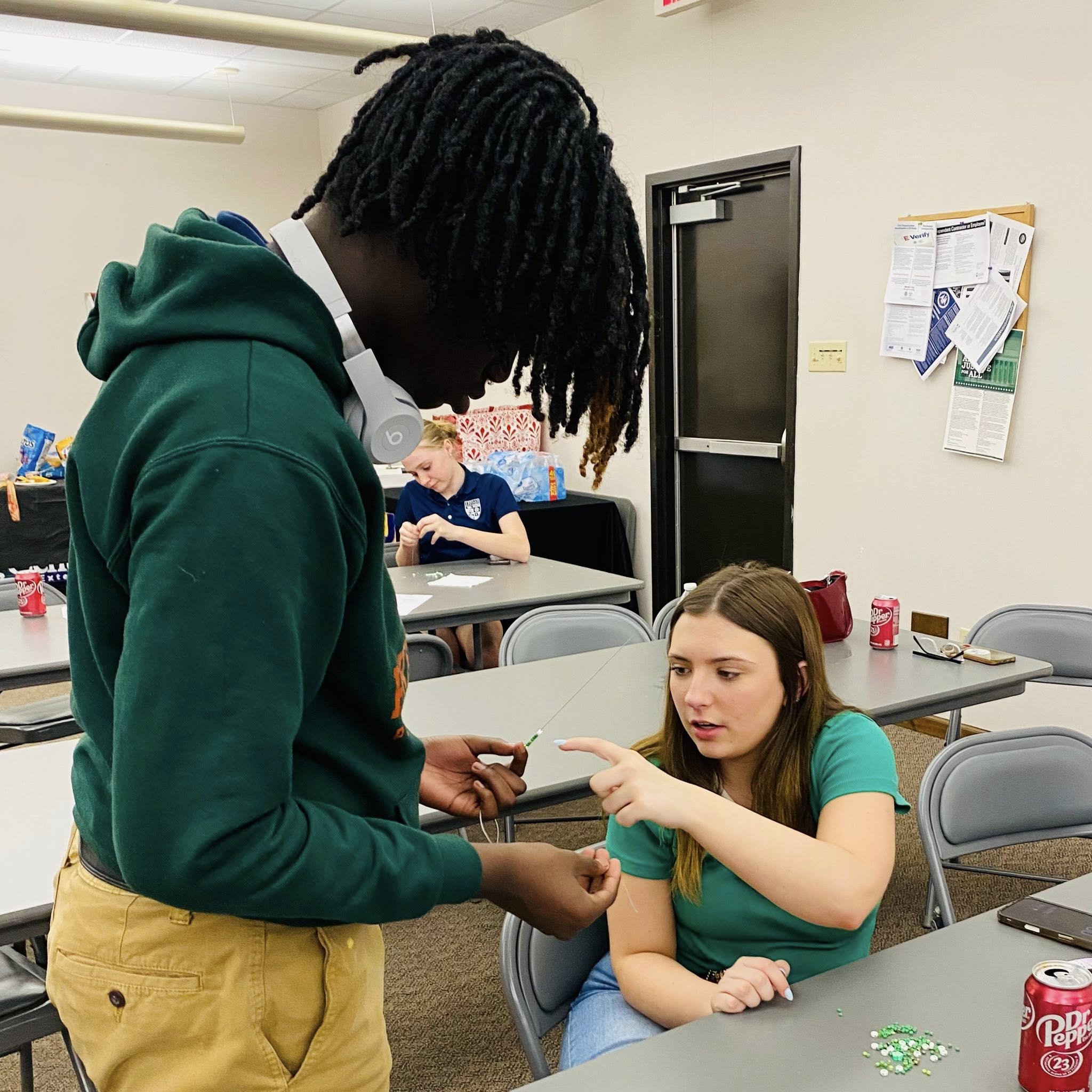A boy handing something to a girl.
